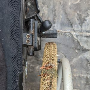 dirty wheelchair tyre with bird poo in the treads and dirty brakes