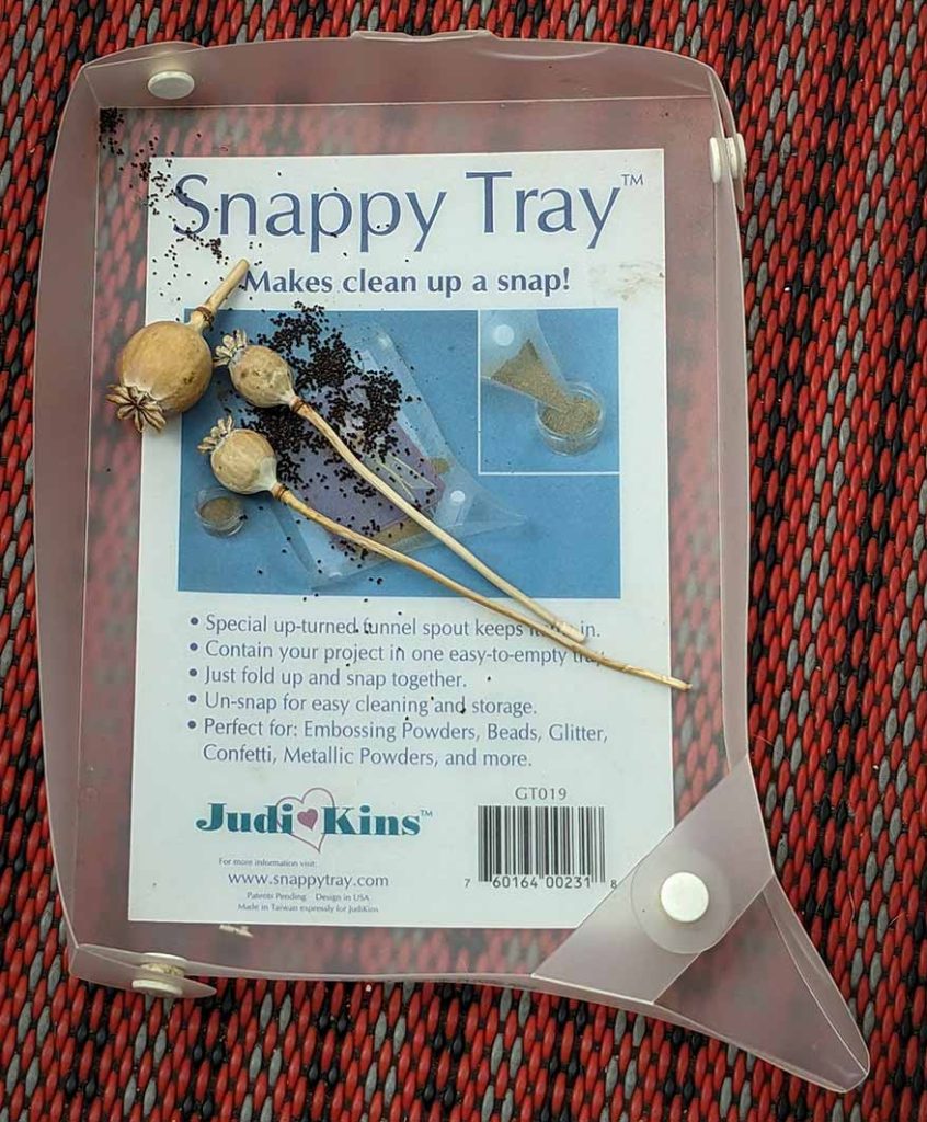 Plastic tray that you stud together that has a funnel at one corner for allowing things like seeds or glitter to go down.